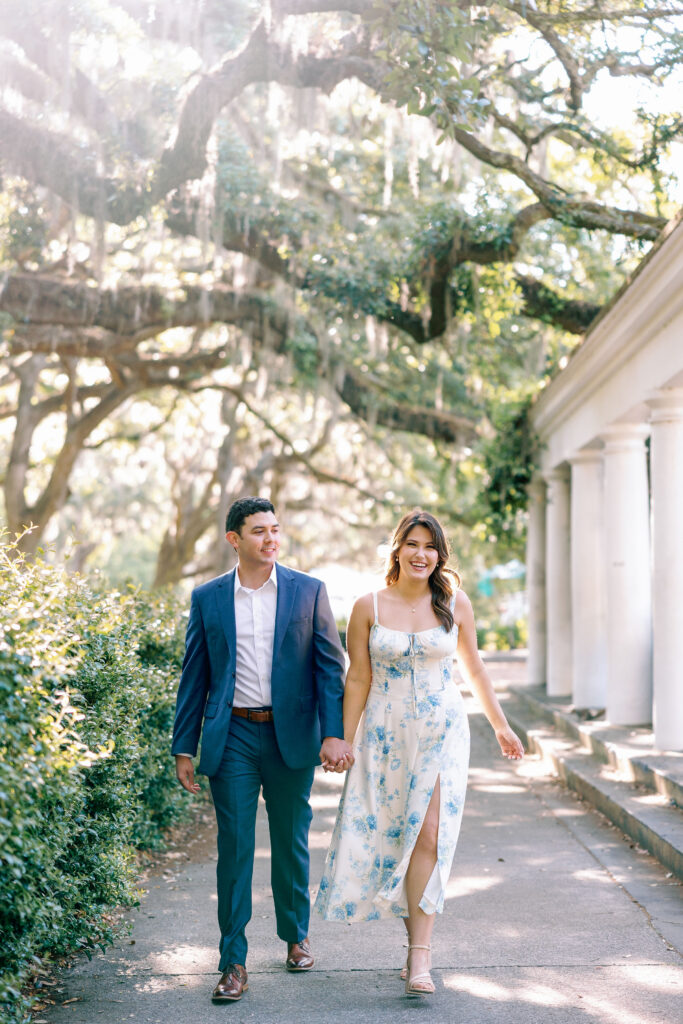 Couple walking hand in hand beneath oak trees near Forsyth Park in Savannah