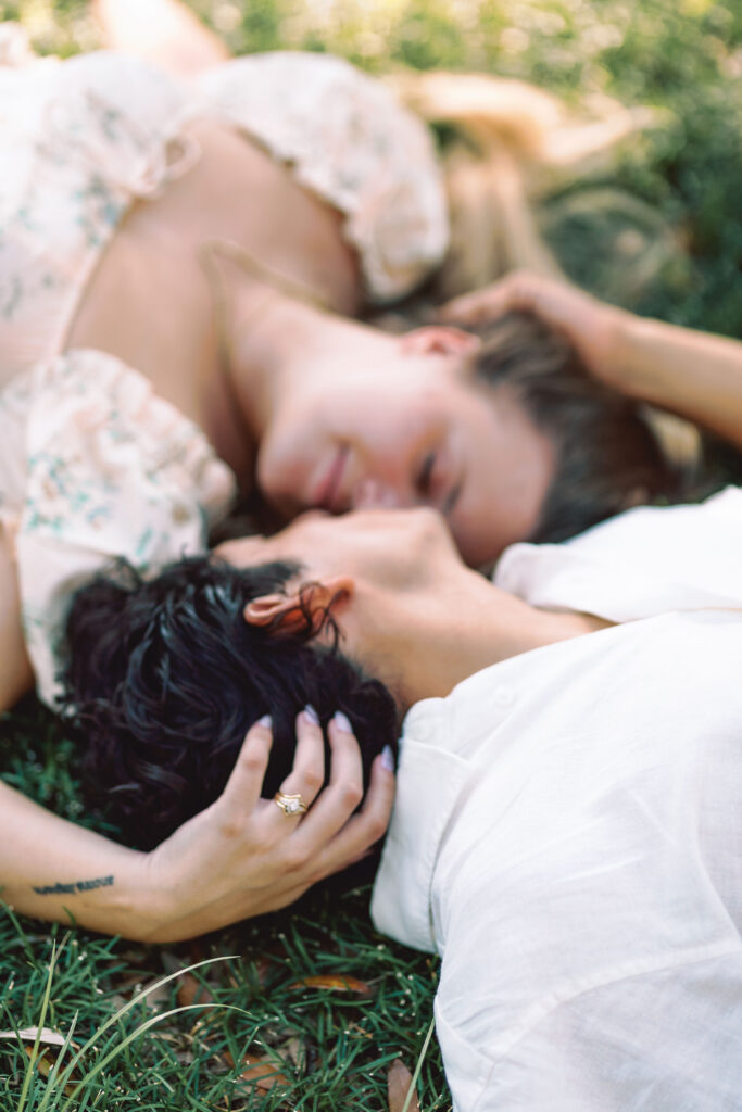 Engaged couple lying in the grass and sharing a quiet moment at Forsyth Park