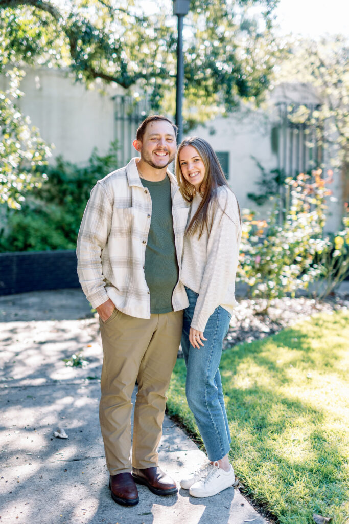 Casually dressed couple smiling together in a garden near Forsyth Park